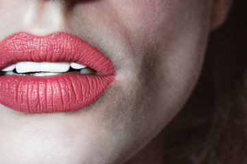 Seductive female lips. Sexually ajar mouth with white teeth. Female painted lips. Peach lips. Defiant lips. Natural lipstick. Sexy face of a girl close-up. Open mouth.