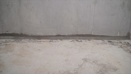 A worker vacuums a concrete floor. Construction services for cleaning the sleeve with an anchor bolt. dust removal with a vacuum cleaner