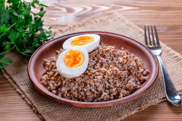 Buckwheat with vegetables on a wooden background.