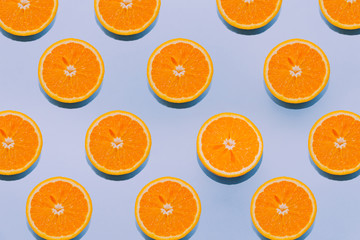 orange pattern.Citrus fruit.Oranges on blue background.Summer mood.Oranges flat lay.Wallpaper.Fruit concept.Repeating object.Cover for the site.Fresh slices of orange.Bright aesthetic backdrop.