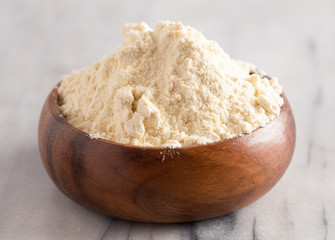 Fototapeta na wymiar Bowl of Millet Flour in a Wood Bowl on a White Marble Countertop