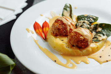 Mashed potatoes with cheese balls in sauce. cheese balls breaded and deep fried. Deep-fried cheese balls