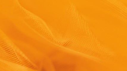 Small mesh fabric on orange 16:9 panoramic background. Shades of orange color
