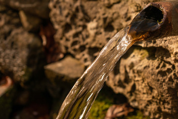 An old hand made fountain in the deep forest of Vitosha mountain near Simeonovo neighborhood, full of water in springtime.