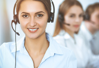 Call center. Focus on beautiful business woman in headset