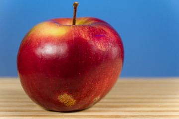 juicy apple isoloated on blue background on the desk