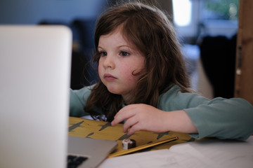 Young child home schooling with laptop during the lockdown