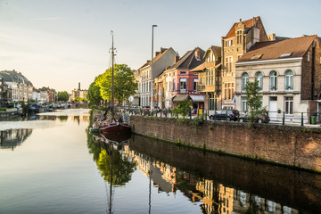 reflection of colorful homes in canal in belgium