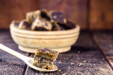 piece of sweet brown sugar, in a rustic wooden spoon. Sweet typical of Brazil and Latin America, made with sugar cane