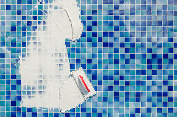 repairing and service of the pool. grouting tiles in the pool. Applying gap filling adhesive sealant or grout with a plastering trowel to the tiles in a swimming pool. - obrazy, fototapety, plakaty