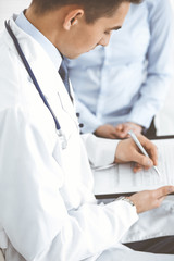 Male doctor using touchpad or tablet pc while consulting female patient in hospita. Medicine and healthcare concept