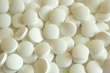 White pills on white background close-up