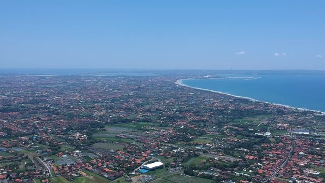 center of bali indonesia aerial, red roofs visible, bali airport, green rice fields and ocean on background