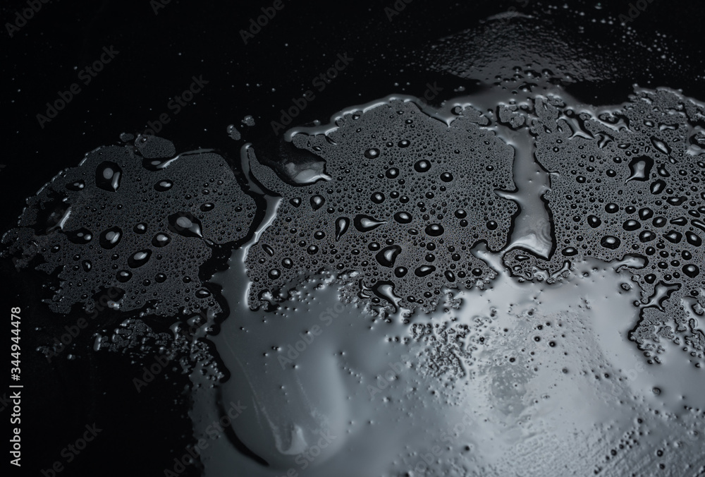 Wall mural drops of water on a black plastic surface