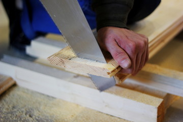 a saw cuts wooden boards, which is in the hand of a man, the concept of repair, construction, natural materials