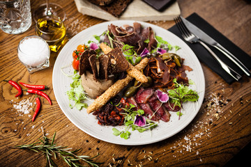 Meat platter for two: Dry-aged beef brisket, dry-aged duck fillet, beef liver pate, dry-aged lamb striploin, cranberry jam and grissini. Delicious healthy Italian traditional antipasti snacks food