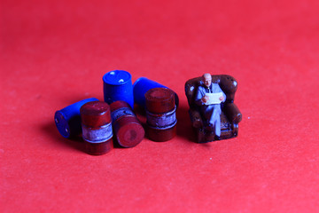 Photo Close Up, Scale HO Sitting old Businessman Beyond Red and Blue Oil Barrel, for your element design oil or fuel related
