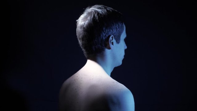 Man spins at dark room, looped