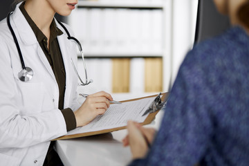 Doctor and patient discussing current health examination while sitting in clinic. Perfect medical...