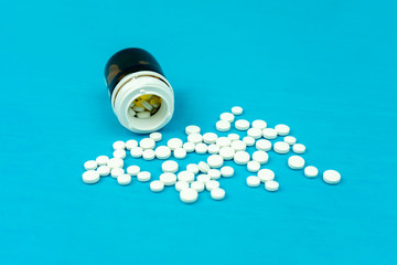 a bottle of pills and pills scattered around on a blue background