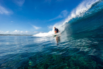 muscular surfer riding on big waves on the Indian Ocean island of Mauritius