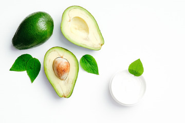 Natural avocado cosmetic cream in jar on white background. SPA organic cosmetic for hand skin care, body treatment. Flat lay, top view