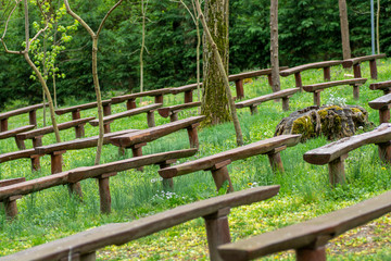 Old brown wooden benches on the grass field.