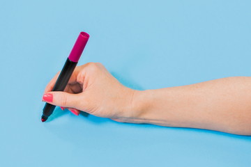 Woman holding pencil on blue background