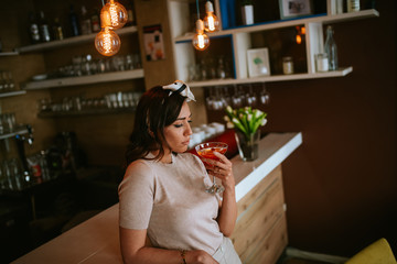 Attractive young caucasian woman drinking alcohol in a cafe