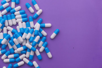 white and blue color capsule on purple background 