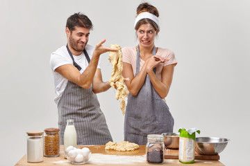 Man cooks shows bad sticky dough, has unlucky day, add something wrong from ingredients, dissatisfied with results of their work. Unhappy couple have cuisine course, need experience of cooking