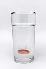 soluble effervescent multivitamin in a glass glass with water on a white background