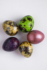 Easter multicolored quail spotted eggs lie on a white background