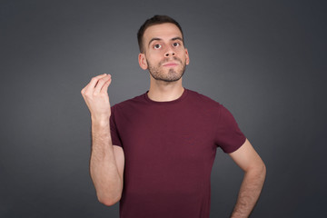 What the hell are you talking about. Shot of frustrated young European man gesturing with raised hand doing Italian gesture, frowning, being displeased and confused with dumb question.