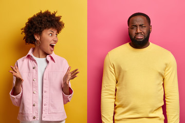 Black couple arguing. Annoyed curly haired woman gestures angrily, displeased man made bad mistake,...