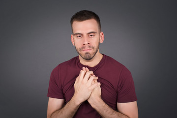 Sad pretty guy feeling upset while spending time at home alone. Handsome young blond male  staring at camera with unhappy or regretful look standing indoors.