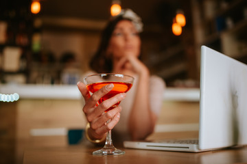 Attractive young caucasian woman drinking alcohol in a cafe