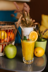 Close up of orange juice next to fruit on table