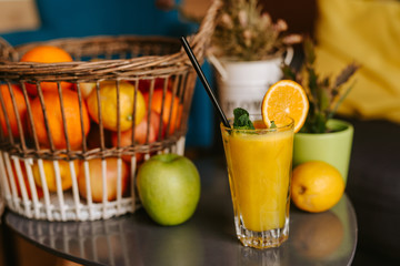 Close up of orange juice next to fruit on table