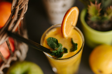 Close up of orange juice next to fruit on table