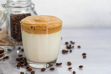 Dalgona coffee is a trendy cold Korean drink. Tasty, aromatic coffee with milk and sugar in a glass on a white background.