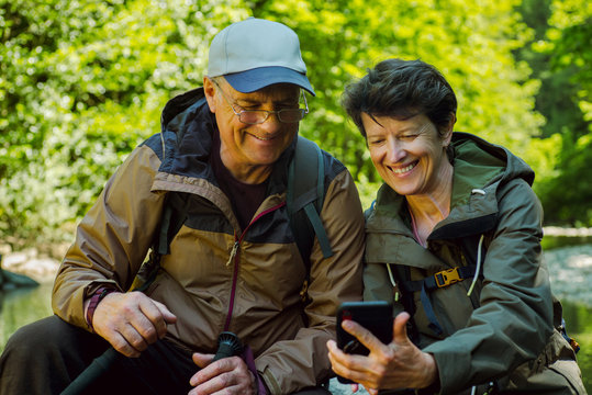 Smiling couple of travelers taking selfie by smartphone