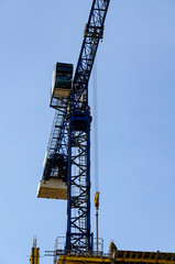 Fototapeta na wymiar Blue tower crane on a background of clear sky. Vertical format.