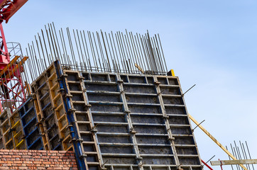 Steel reinforcement and jellied concrete structures against the blue sky.