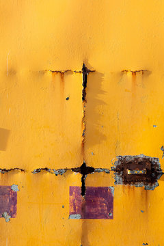 Detail of yellow door with rust