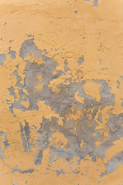 worn concrete patches on a yellow wall.