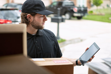 Shipment: Delivery Man Checking Number On Digital Tablet