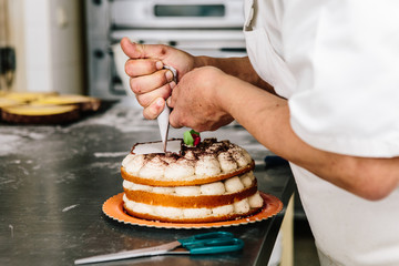 Patisserie maker piping a cake