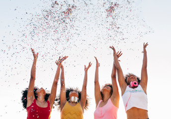 Afro women throwing confetti on air