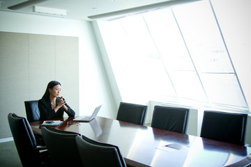 Thoughtful businesswoman sitting in conference room